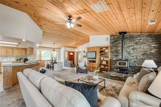 carpeted living room with wood ceiling, high vaulted ceiling, a wood stove, and ceiling fan