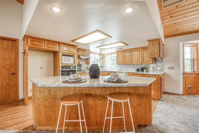 18486 Tollhouse Rd, Clovis, CA 93619 - kitchen with oven, white microwave, plenty of natural light, baseboards, and recessed lighting
