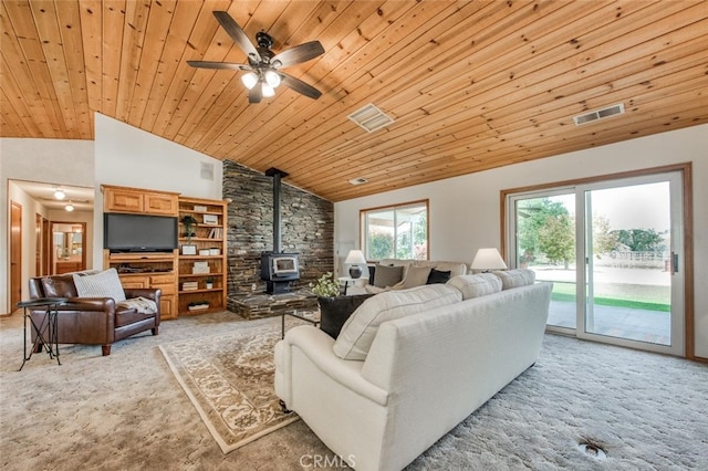 carpeted living room with ceiling fan, high vaulted ceiling, a wood stove, and wooden ceiling