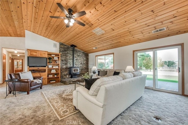 18486 Tollhouse Rd, Clovis, CA 93619 - living area featuring a wood stove, light colored carpet, wood ceiling, vaulted ceiling, and ceiling fan