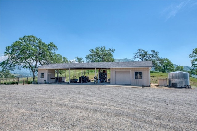 exterior space featuring a garage, an outbuilding, and a carport