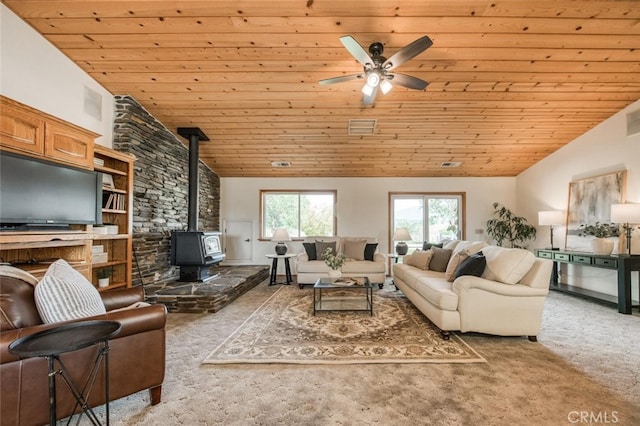 carpeted living room featuring a wood stove, wooden ceiling, and lofted ceiling