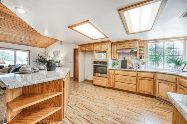 18486 Tollhouse Rd, Clovis, CA 93619 - kitchen featuring stainless steel oven, open shelves, white microwave, under cabinet range hood, and lofted ceiling