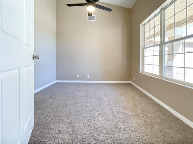 carpeted empty room featuring a ceiling fan, visible vents, and baseboards