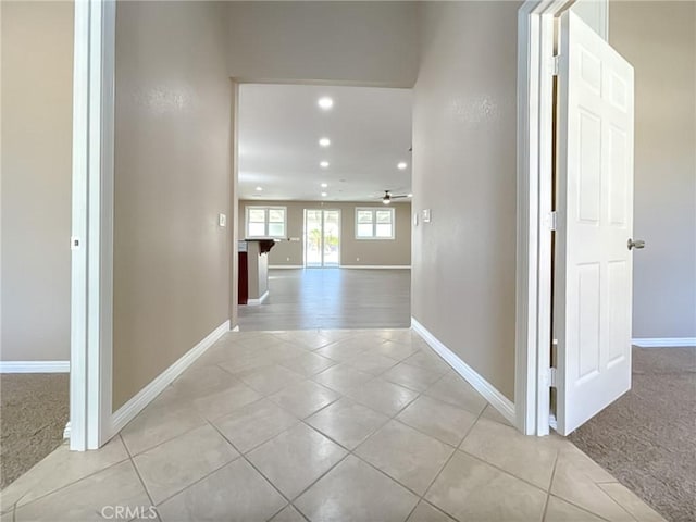 hallway featuring light colored carpet