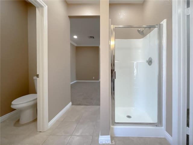 bathroom with a stall shower, tile patterned flooring, toilet, and baseboards