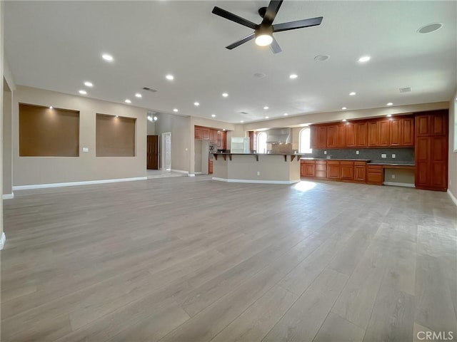 unfurnished living room with ceiling fan and light hardwood / wood-style flooring