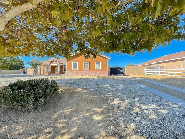 ranch-style home featuring brick siding and fence