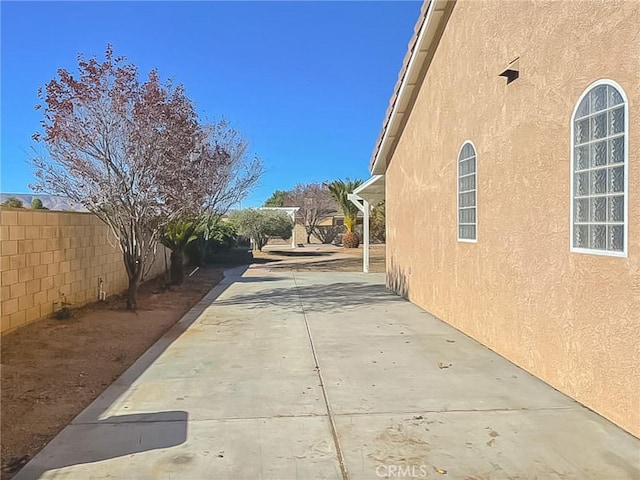 view of property exterior with a patio area, a fenced backyard, and stucco siding