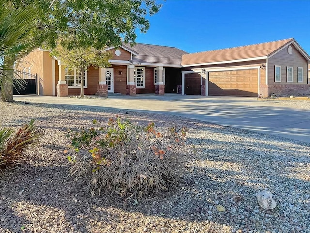 view of front facade with an attached garage, concrete driveway, and a tiled roof