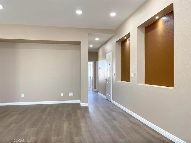 corridor featuring recessed lighting, baseboards, and wood finished floors