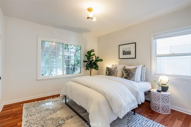 bedroom featuring multiple windows and hardwood / wood-style flooring