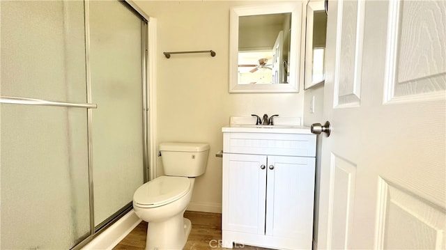 bathroom featuring toilet, walk in shower, vanity, and hardwood / wood-style flooring