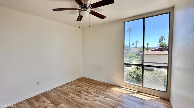 spare room with light hardwood / wood-style floors, ceiling fan, and a wealth of natural light