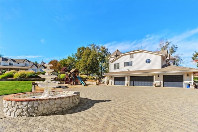 exterior space with a playground and a garage