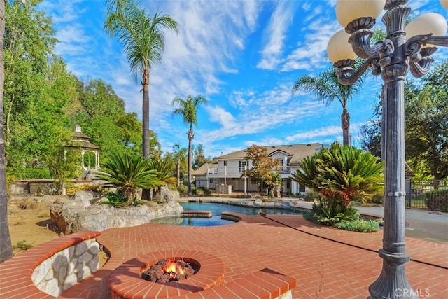 view of swimming pool featuring an in ground hot tub and a patio