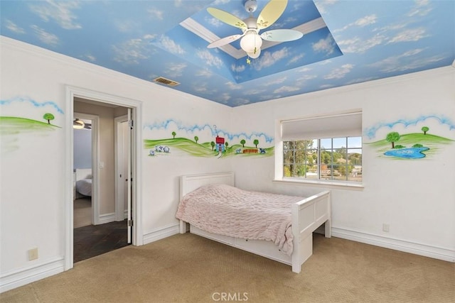 carpeted bedroom featuring a tray ceiling, ceiling fan, and ornamental molding