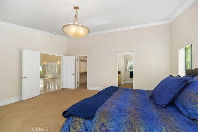 carpeted bedroom featuring ensuite bath and crown molding