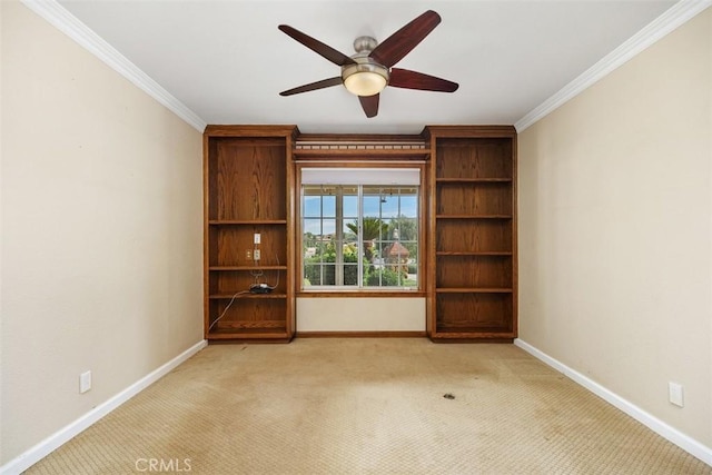 carpeted spare room featuring ceiling fan and crown molding