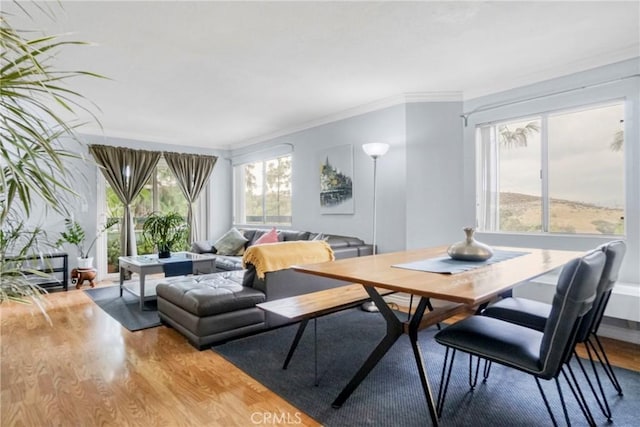 dining space with light wood-type flooring and crown molding