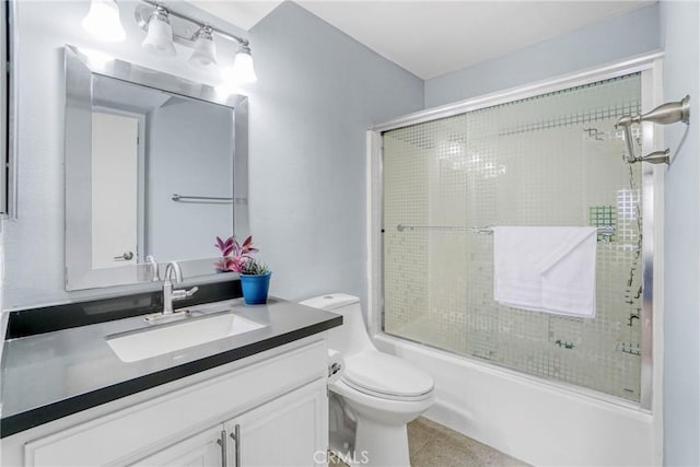 full bathroom featuring tile patterned flooring, vanity, toilet, and bath / shower combo with glass door