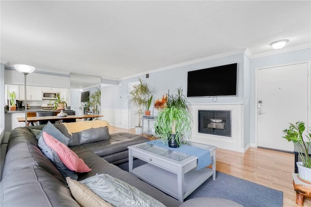 living room featuring light hardwood / wood-style flooring and crown molding