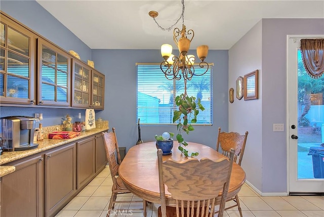 tiled dining room with a wealth of natural light and an inviting chandelier