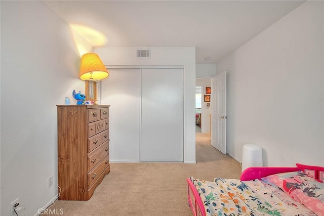 bedroom featuring light carpet and a closet