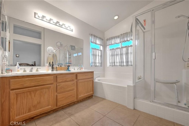 bathroom featuring tile patterned flooring, shower with separate bathtub, vanity, and vaulted ceiling