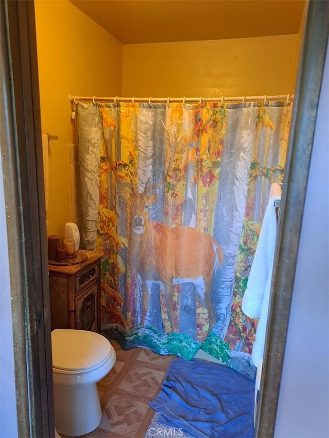 bathroom with parquet flooring and toilet