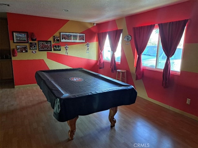 game room featuring lofted ceiling, a textured ceiling, wood-type flooring, and a wealth of natural light