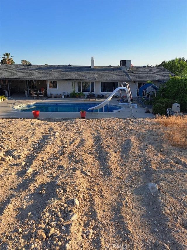 view of pool with a patio area and a water slide