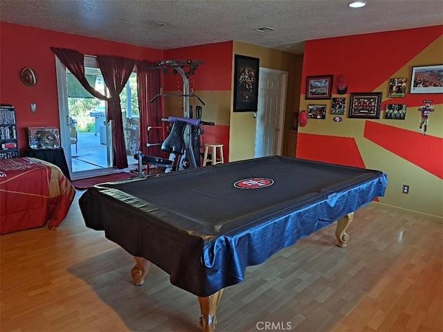 recreation room with billiards, wood-type flooring, and a textured ceiling