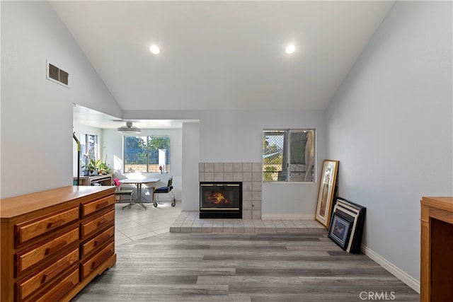 living room featuring vaulted ceiling, wood-type flooring, and plenty of natural light