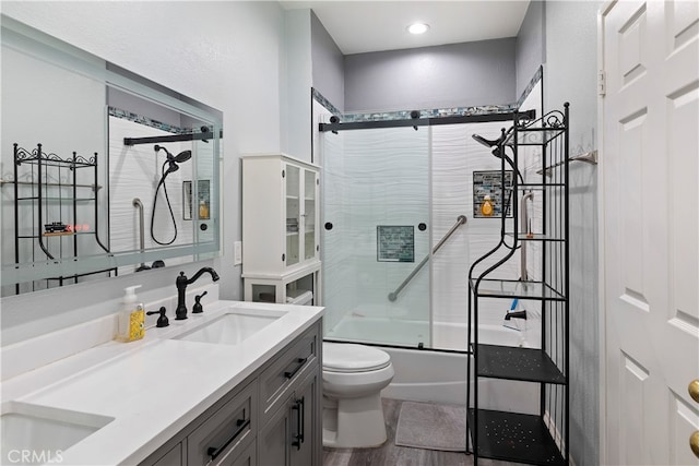 full bathroom with vanity, toilet, hardwood / wood-style flooring, and bath / shower combo with glass door