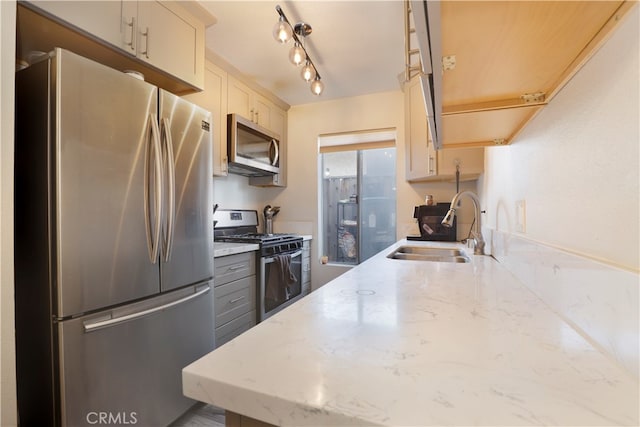 kitchen with sink, light stone countertops, and stainless steel appliances