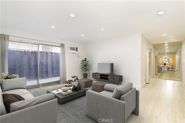 living room with light hardwood / wood-style floors and a wall mounted air conditioner