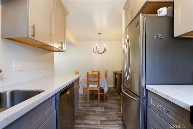 kitchen with dark wood-type flooring, appliances with stainless steel finishes, gray cabinets, and hanging light fixtures