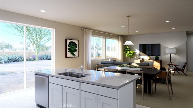 kitchen with stainless steel dishwasher, sink, white cabinetry, and a healthy amount of sunlight