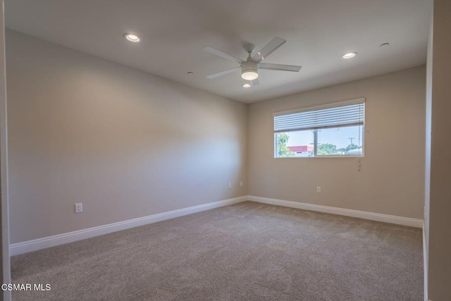 unfurnished room with light colored carpet and ceiling fan