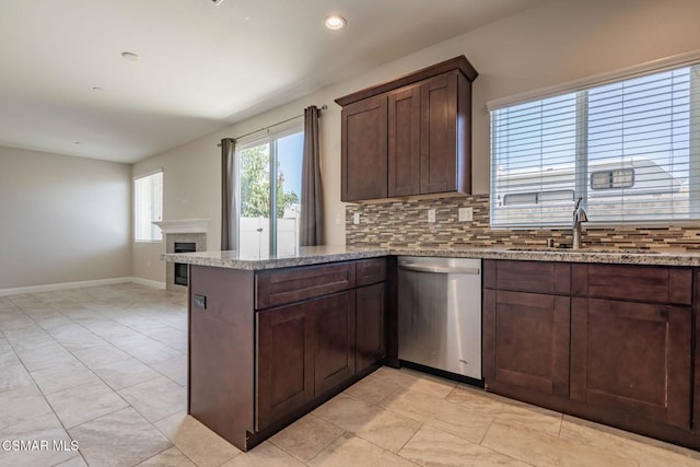 kitchen with kitchen peninsula, tasteful backsplash, dark brown cabinets, dishwasher, and sink