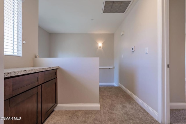 hallway featuring light carpet and plenty of natural light