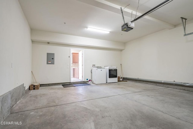 garage featuring independent washer and dryer, a garage door opener, and electric panel