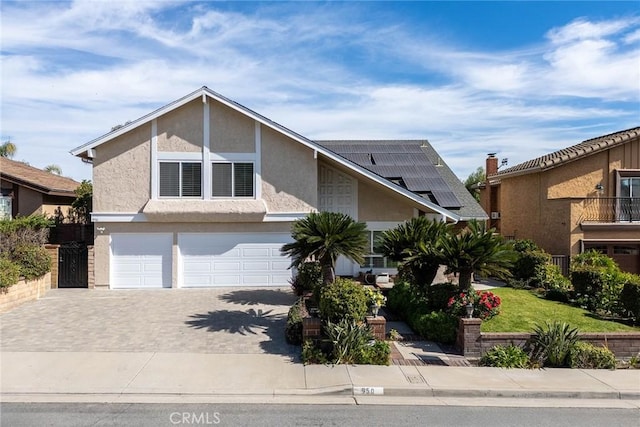 view of front of property featuring solar panels and a garage