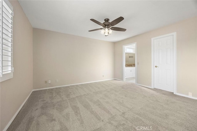 unfurnished bedroom with ceiling fan, light carpet, and ensuite bath