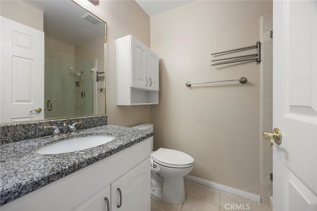 bathroom featuring tile patterned flooring, vanity, toilet, and walk in shower