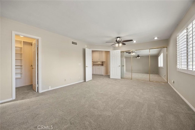 unfurnished bedroom featuring ceiling fan and light colored carpet