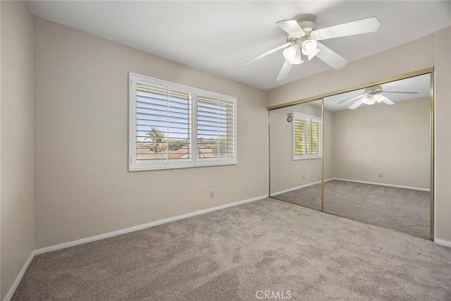 unfurnished bedroom featuring multiple windows, ceiling fan, a closet, and light colored carpet