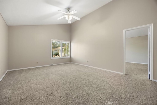 empty room featuring carpet floors, high vaulted ceiling, and ceiling fan