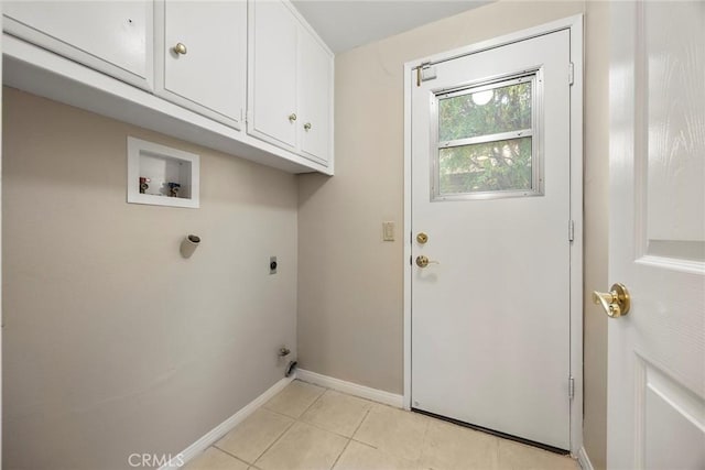 washroom featuring hookup for an electric dryer, cabinets, light tile patterned floors, and hookup for a washing machine